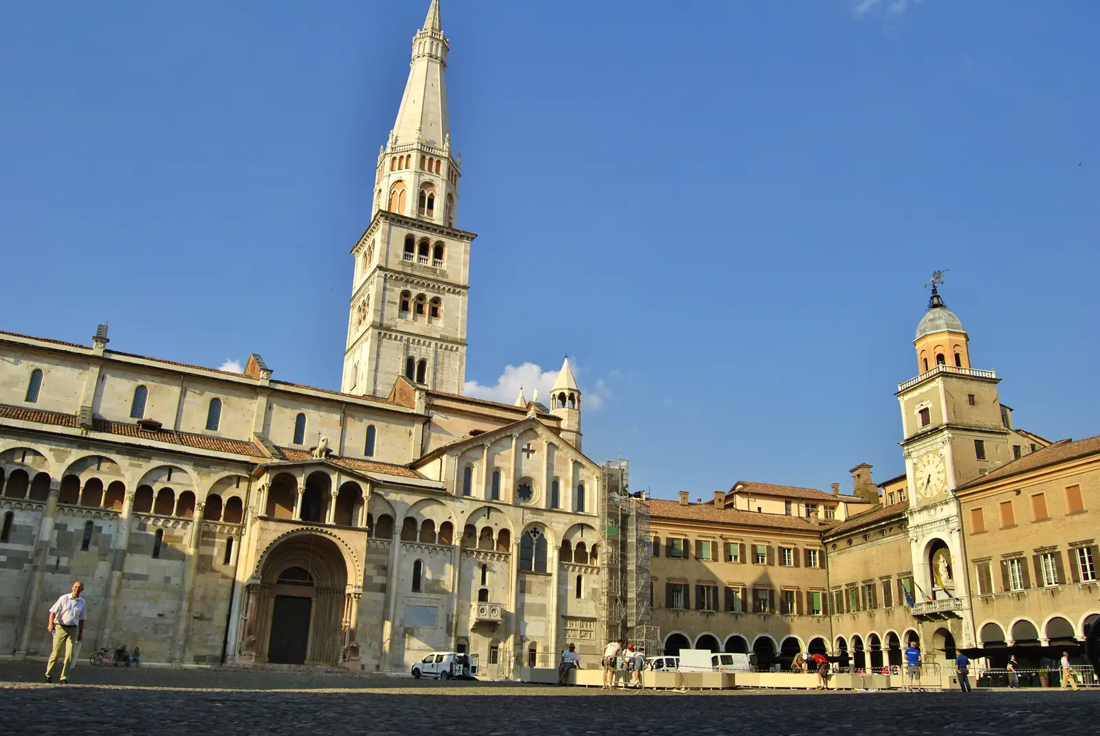 Modena Cathedral and its tall Ghirlandina bell tower on Piazza Grande under a blue sky