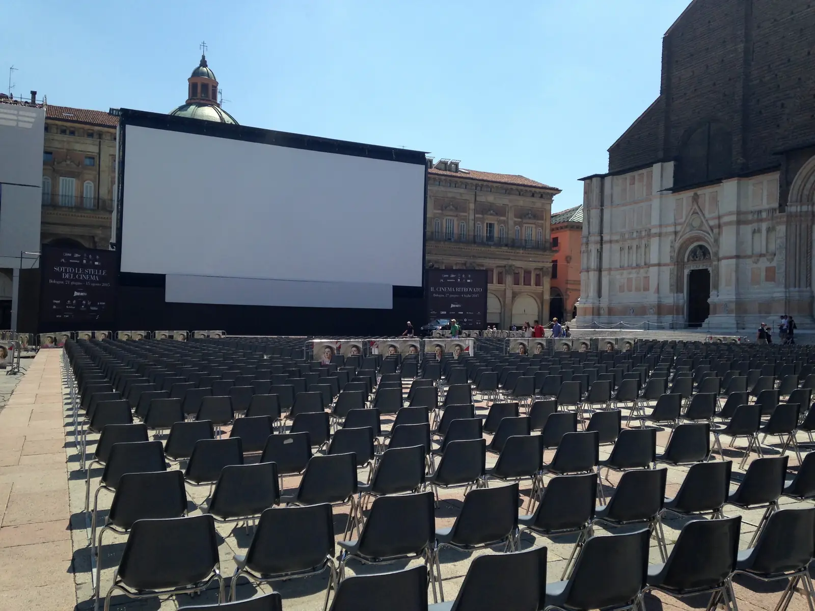 The open-air cinema screen and rows of seats set up in Piazza Maggiore in front of the Basilica di San Petronio